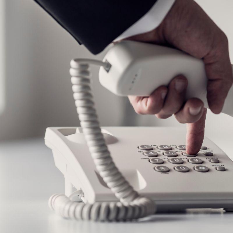 Person dialing on a telephone